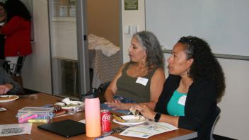 two women listen to presentation
