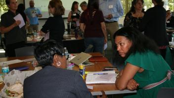 two women talking with group behind them
