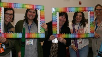 five educators with crayon and picture frame props