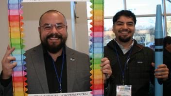 two educators with crayon and picture frame props