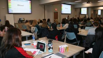 educators listening to presenters in conference room