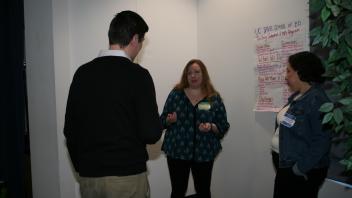 three people standing talking