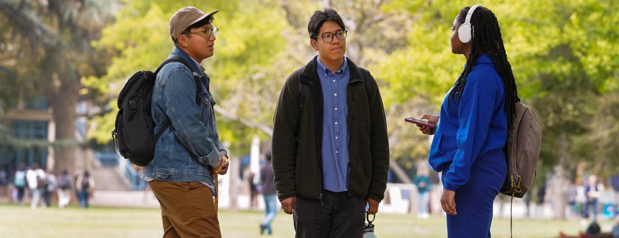 three students talking to each other