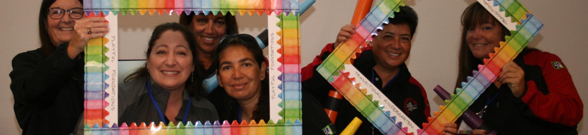 four educators with crayon and picture frame props